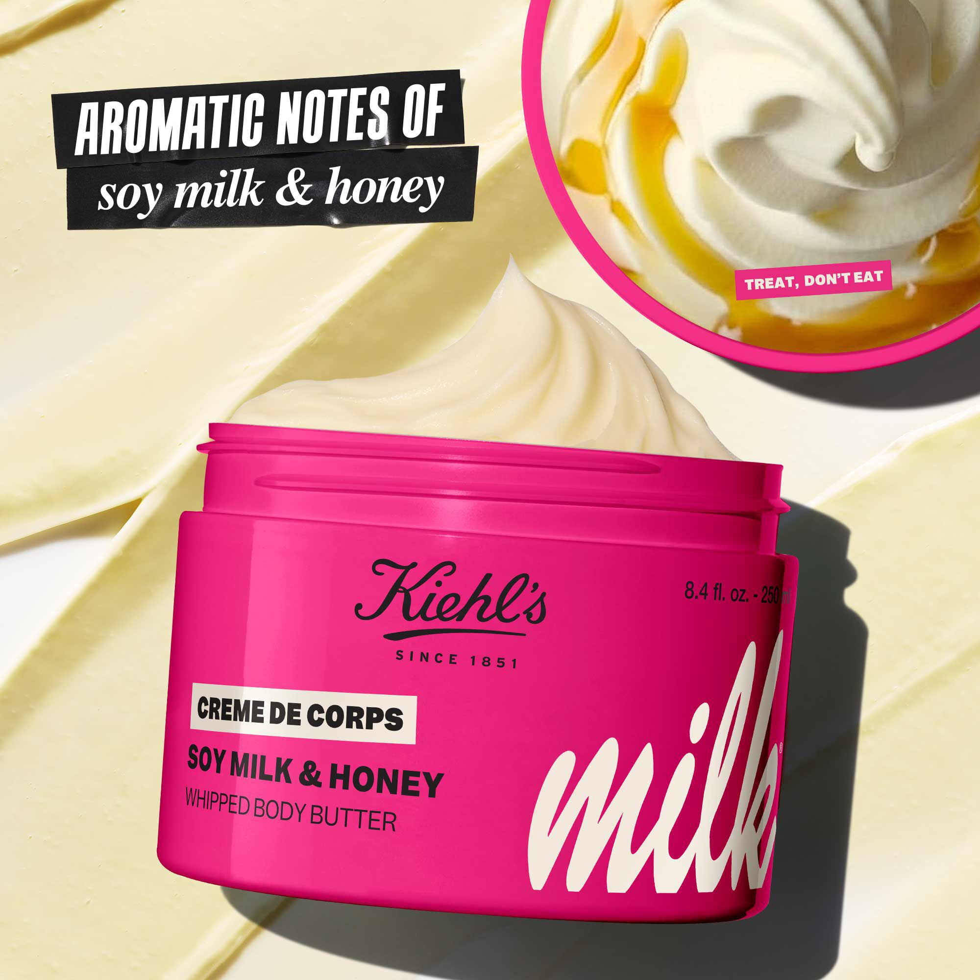 Open jar of Kiehl’s Milk Bar Creme de Corps Whipped Body Butter in bright pink limited-edition packaging, with cream shown in the lid and text highlighting aromatic notes of soy milk and honey.​